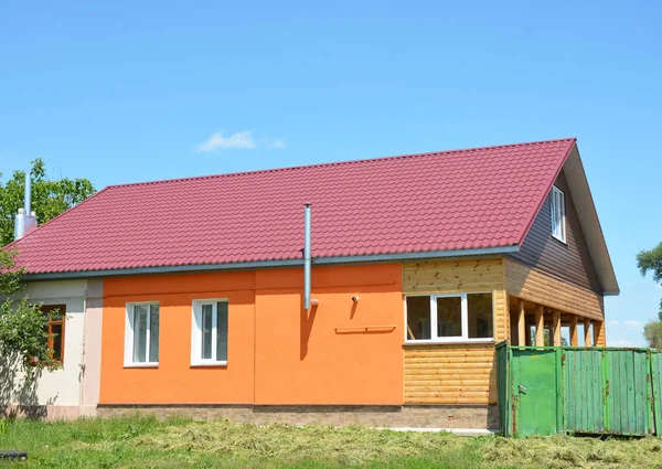 Building house with metal roof, steel gas chimney, wooden veranda, plastering and painting walls.
