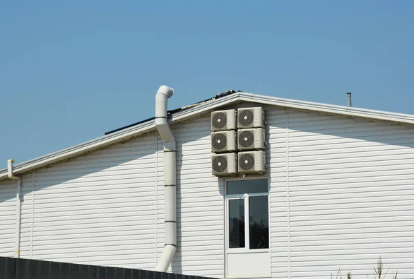 Ventilation systen on siding house construction with air compresors and chimney.