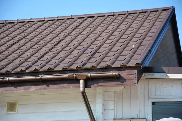 Rain gutter system. Metal roof with plastic roof guttering.