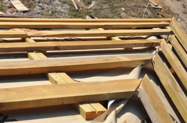 Ahşap kirişler, saçak, membran, günlükleri ve ahşap evin çatı köşesinde su yalıtımı yükleme