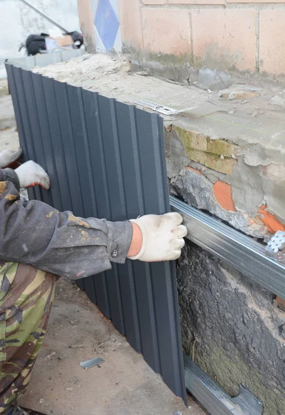 Contractor with Foundation Repair. House foundation wall repair and renovation  with installing metal sheets for waterproofing and protect from rain.