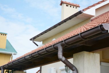Guttering. Roof gutter pipeline sysem. House rain gutter with holders and downspout pipe. clipart