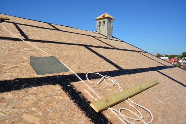 Roofing preparation asphalt shingles installing on house construction wooden roof with bitumen spray and  protection rope, safety kit. Roofing construction.