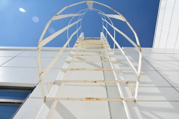 A fire escape stairs is a type of emergency exit that is external to a building. Steps to success concept with blurred lights. Fire escape ladder.