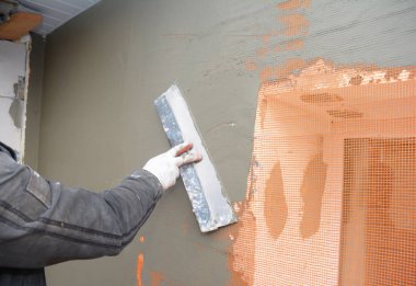 Oluşturucu sıva duvar spatula, fiberglas ağ, ile alçı kafes sert köpük yalıtım sonra. 