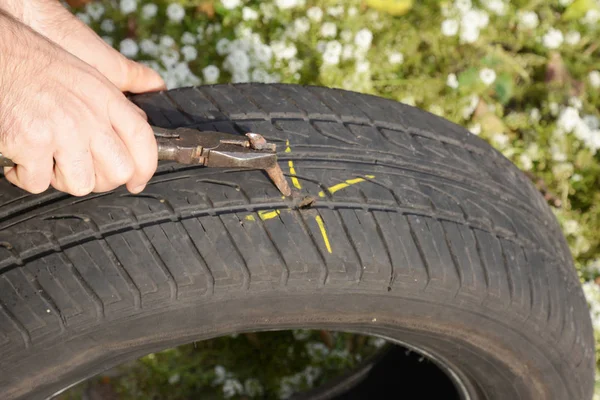 Fix flat car tire.  Car tire damage with nail.