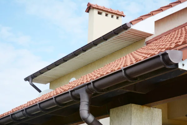 屋根工事の煙突 赤い粘土のタイル張りのバレーと切妻屋根タイプの新しい家上の雨溝システム — ストック写真