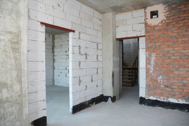 Beyaz ve kırmızı tuğla, sıva duvar, su yalıtım kat, metal kapı lentosu üzerinde boş oda iç yapı.