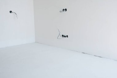 Boş ev oda beyaz sıva duvarlar ve bitmemiş çıkış fişi yükleme.