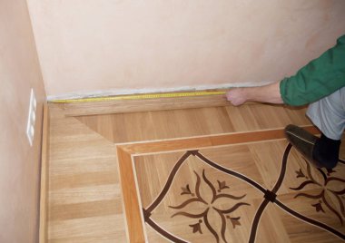 Ahşap çıta kurulum ve onarım meşe ahşap parke üzerinde. Ahşap ölçme yüklenici eller ölçü dokunmayla indirelim.