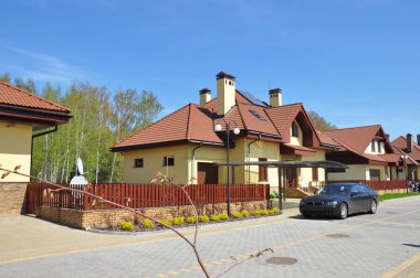 Modern ev güneş panelleri, ışıklıklar, garaj ve erken baharda banliyö evlerin sokak üzerinde yeni otomobil