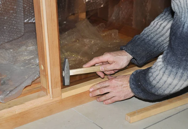 工人与锤子和钉子修理玻璃门 — 图库照片