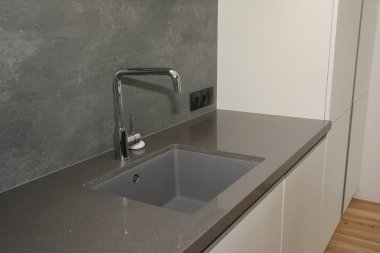 Siyah mutfak lavabo ve mutfak musluk suyu. Modern mutfak metal musluk ve lavabo.