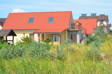 Kırmızı çatı, balkon ve çatı penceresi ile kırsal modern ev