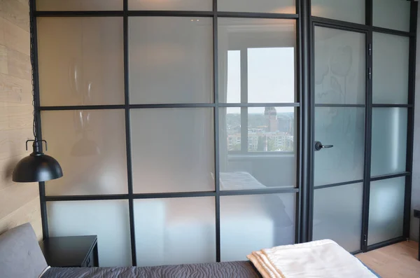 Modern bedroom zoning with glass wall.  Modern bedroom interior with cozy glass wall and door.