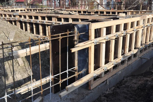 Железные и деревянные каркасы для строительства фундамента дома uder строительства. Незавершенное строительство фундамента дома . — стоковое фото