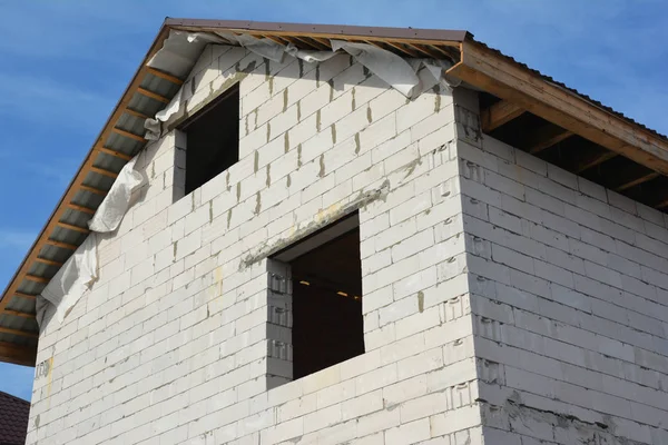 Construcción de casa nueva con fachada de bloques de hormigón aireado, habitación ático, techos de metal — Foto de Stock