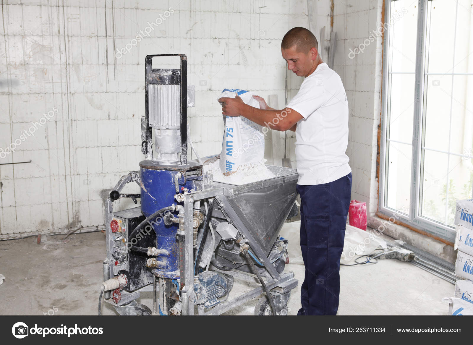 Contractor making plaster concrete with plastering machine for house