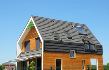 Modern Pasif Ev Dış. Çatı da çatı pencereleri ve güneş panelleri ile modern enerji verimliliği evi.