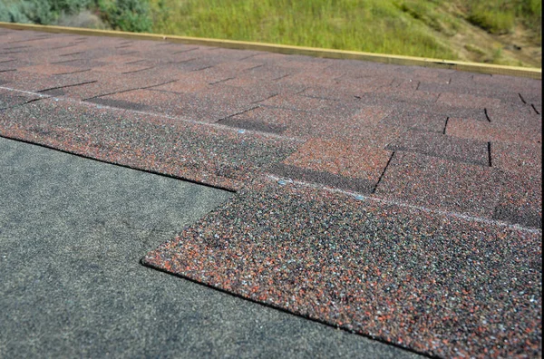 Primer plano en la instalación de tejas, tejas de asfalto. Construcción de techos . — Foto de Stock