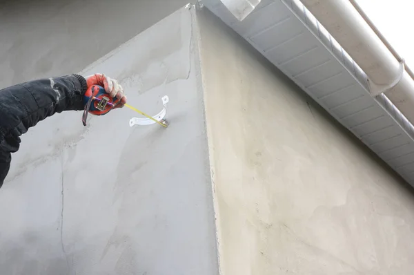 Entreprenör installera hållare för tak rännstenen stuprör pipe — Stockfoto