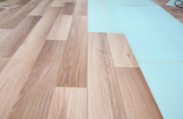 Instalación de suelos laminados de madera con aislamiento y láminas de insonorización . — Foto de Stock