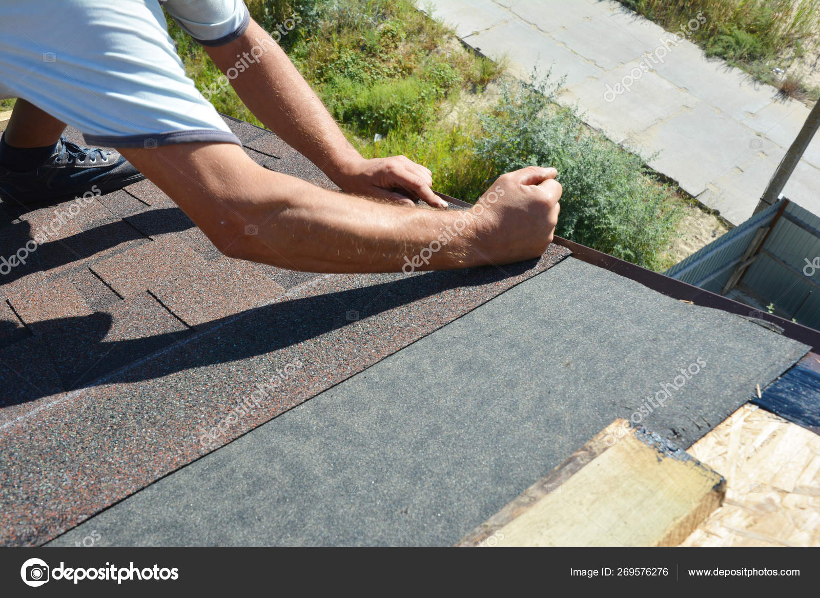 Roofer contractor gluing waterproof membrane on wooden roof top surface  with black bitumen spray on tar and laying asphalt shingles, Roofing  construction. Stock Photo by ©thefutureis 269576276