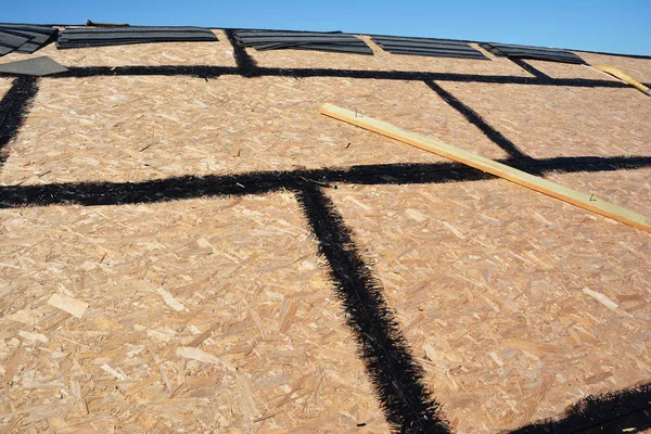 Casa Costruzione tetto tetto in legno compensato, bordo filo orientato (OSB) per l'installazione di tegole di asfalto. Costruzione di coperture . — Foto Stock