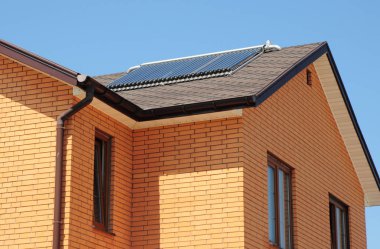 Tuğla ev asfalt zona çatı üst güneş su ısıtıcı, güneş su ısıtma panelleri ile .