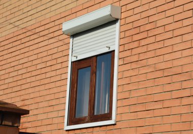 Haddeleme kepenkler ev pencereleri koruma. Pencerelerde metal rulo kepenkler ile Tuğla ev