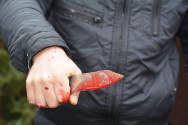 Bıçaklı saldırı konsepti. Katil, katil kırmızı sahte kan damlalarıyla bıçakla saldırıyor.. 