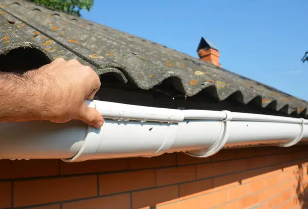 Roofer aannemer installatie en reparatie regengoot pijpleiding. Guttering reparatie met de handen van de aannemer. — Stockfoto