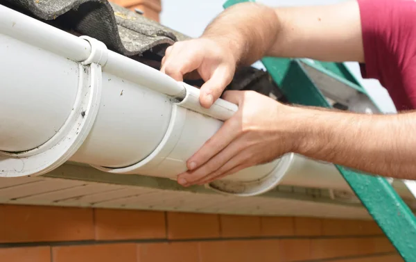 Reparatie van guttering. Roofer aannemer handen installatie en reparatie regengoot. — Stockfoto