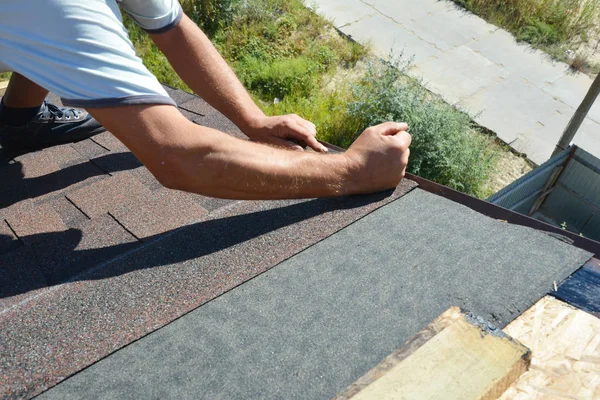 屋根の請負業者はタールに黒いビチューメンスプレーと木製の屋根の上面に防水膜を接着し、アスファルト帯を敷設、屋根の建設. — ストック写真