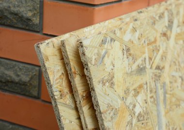 Tuğla ev duvarı nın yanında yönelimli iplikçik tahtası (Osb)