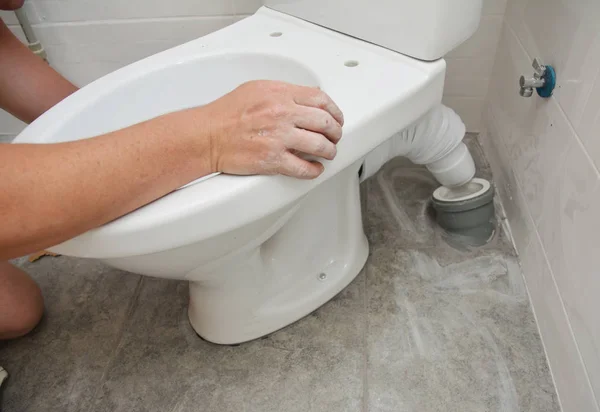 Repairman installing flush toilet, toilet bowl in the bathroom — Stock Photo, Image
