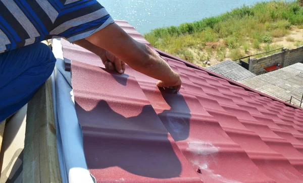 Roofer aannemer installeert dak met lichtgewicht metalen dakpannen. Stalen tegel dakbedekking bouw huis dak — Stockfoto