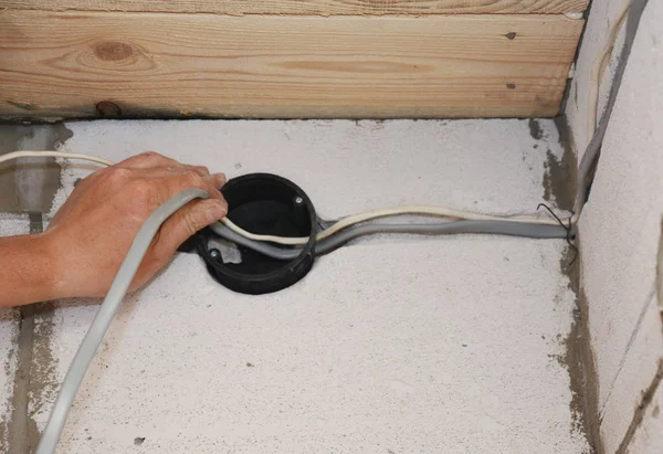 Ηλεκτρι-μπορεί να εγκαθιστά ηλεκτρικά καλώδια στον τοίχο. Εγκατάσταση ηλεκτρικών καλωδιώσεων — Φωτογραφία Αρχείου