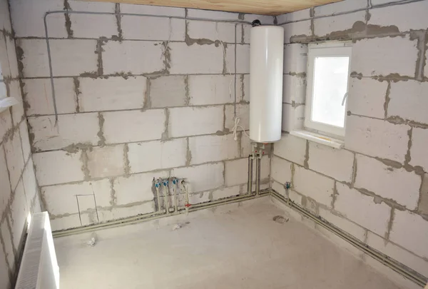 Instalación de caldera eléctrica y ranura o zanja de corte para tubería de agua en la pared del baño — Foto de Stock