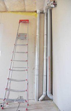 Kanalizasyon ve havalandırma boruları olan bir ev köşesi..