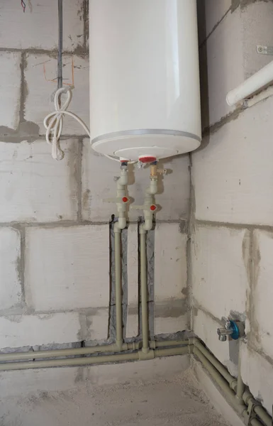 Instalace a skrývání ve stěnách vodovodního potrubí v koupelně domu s elektrickým kotlem. Žlábek nebo příkop řez pro vodní potrubí ve zdi — Stock fotografie