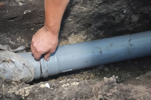 Contractor installing house sewer pipe in the ground trench — Stock Photo, Image