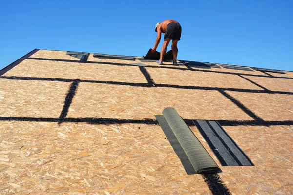 Tejas de asfalto Construcción de techos. Construcción de techos Roofer con tablero de filamento orientado (OSB) e impermeabilización de betún colocando tejas de asfalto, reparación de techos — Foto de Stock
