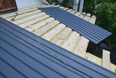 Çatı İnşaatı. Hafif metal çatı kiremitleri ev inşaatına çatı döşemesi kuruluyor