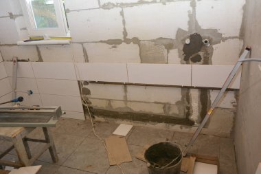 Banyo tadilatı sırasında duvarları elle kesme, havan ve çentikli mala kullanarak boyamak..