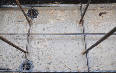 Demir parmaklıklar ve çelik parmaklıklardan oluşan beton temele yakın çekim..