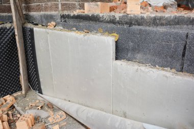 Enerji tasarruflu ev için katı polistiren köpük panolarla temel yalıtımı kuruluyor.