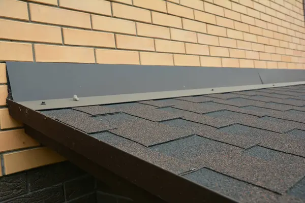 Close up on house asphalt shingles roof wateproofing problem area.