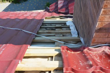 Bacanın yakınındaki sorun bölgesinde metal bir çatının su geçirmez hale getirilmesine yakın plan.