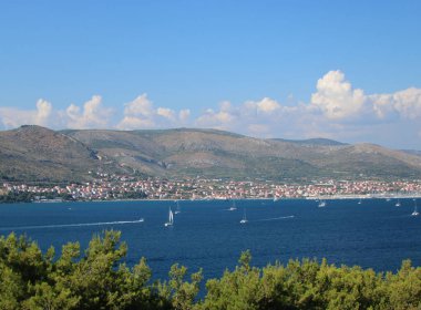 Yaz günü, dağların ve körfezin panoramik manzarası. Yelkenli tekneler körfezi geçiyor.